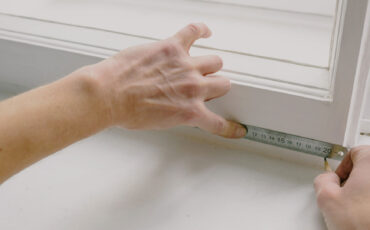 Person measuring a window frame